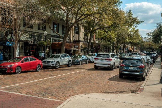 Tree-lined street with parked cars.
